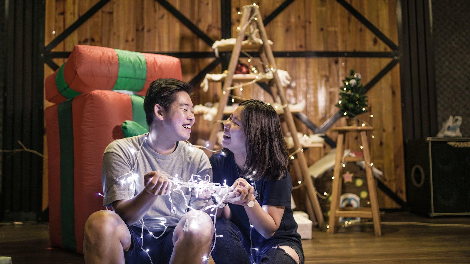 selective focus photography of couple holding lighted string lights