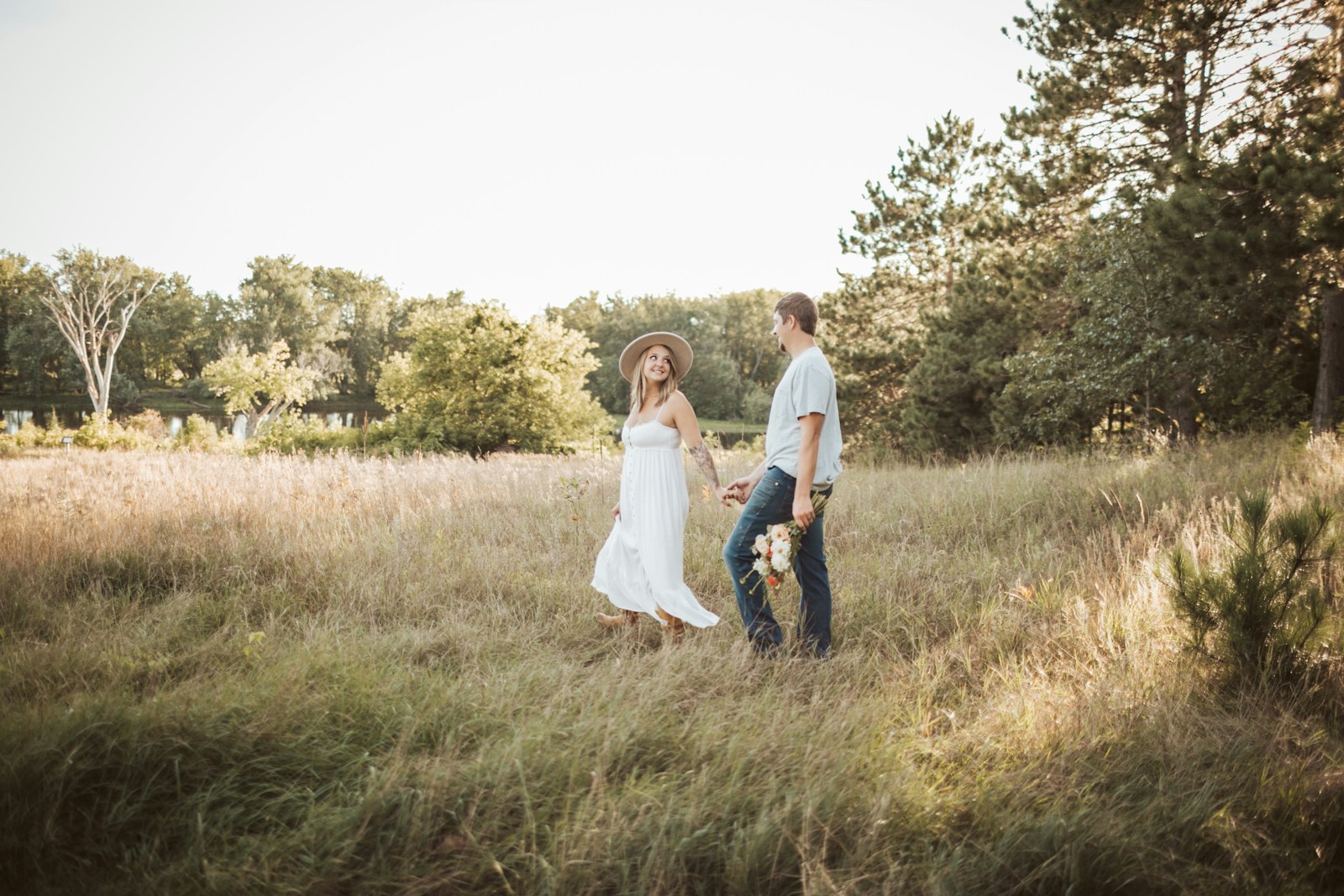 a man and a woman holding hands in a field