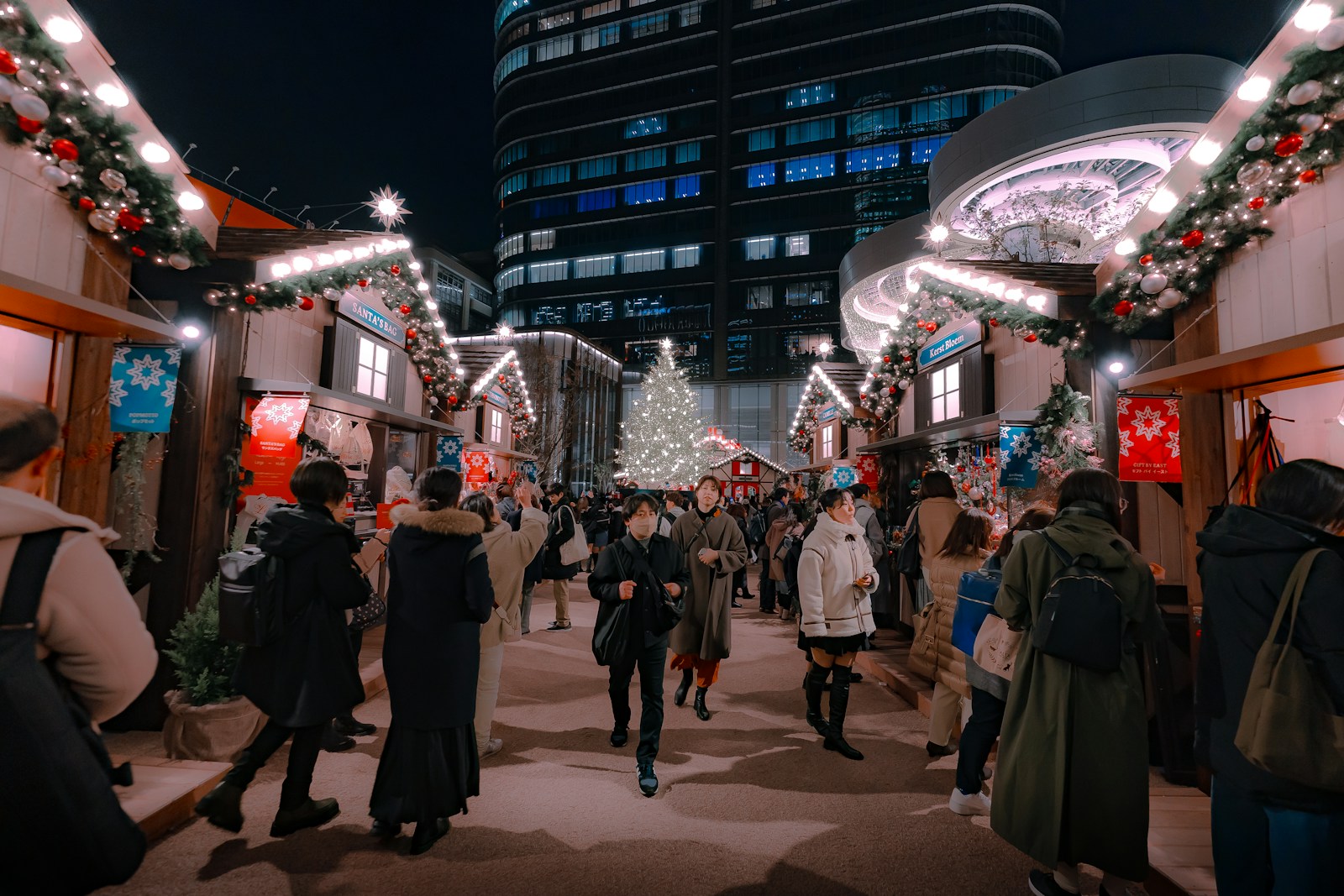 a group of people walking down a street at night
