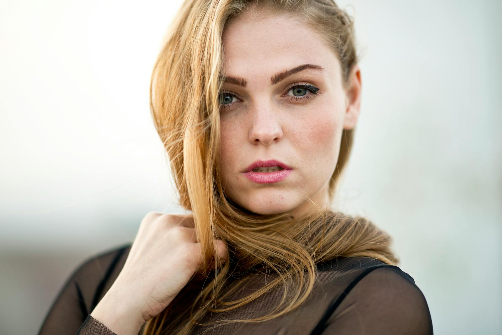 Close-up portrait of a beautiful young woman with blonde hair and striking eyes.