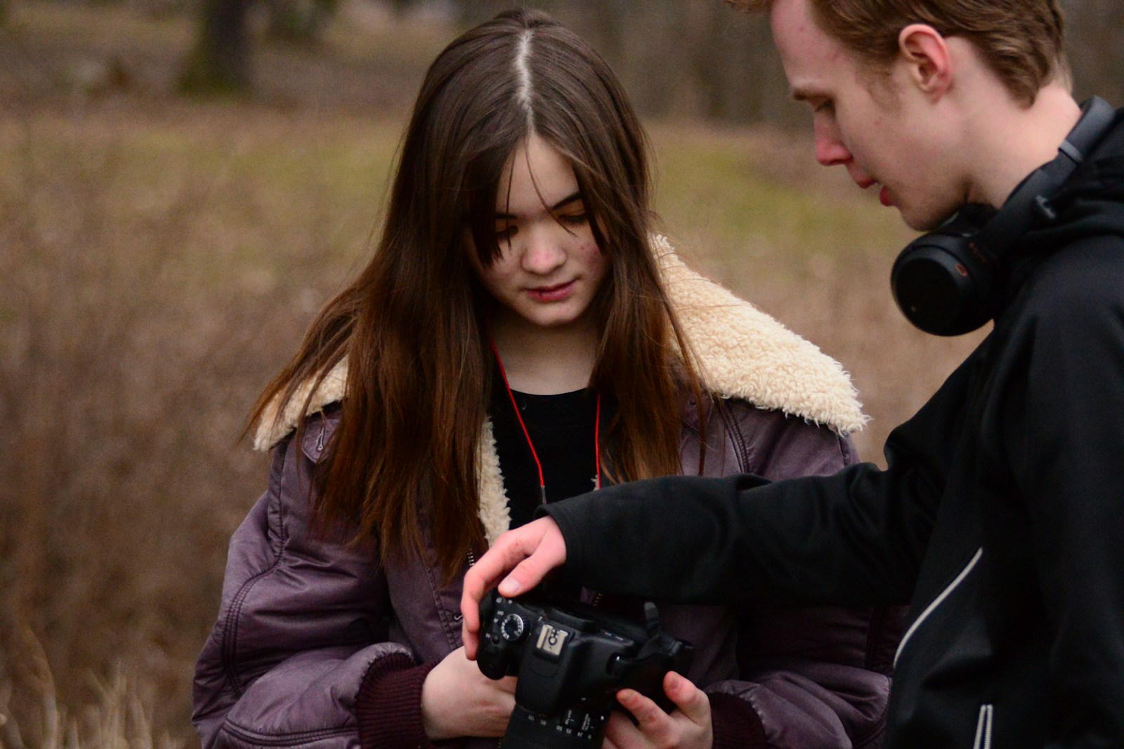 woman in black jacket holding black dslr camera