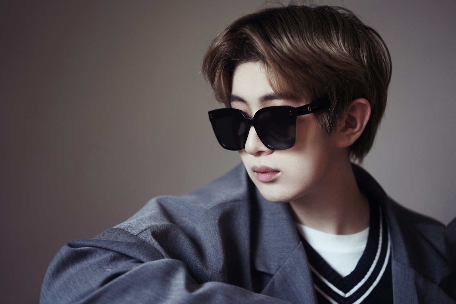 a young man wearing a suit and sunglasses